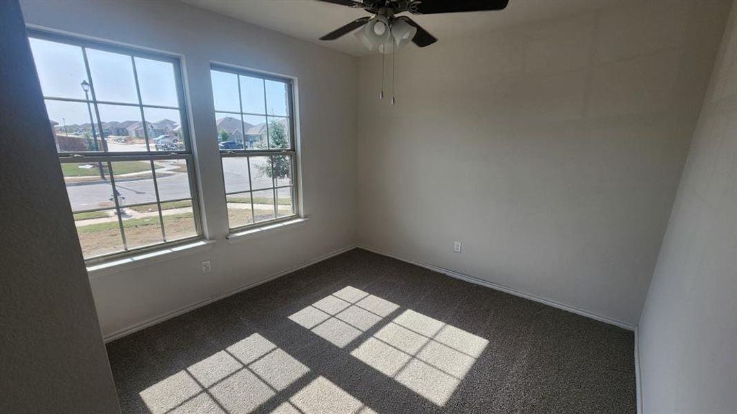 Room featuring two large windows, neutral-toned carpeting, and a ceiling fan with integrated lighting Room featuring two large windows, neutral-toned carpeting, and a ceiling fan with integrated lighting