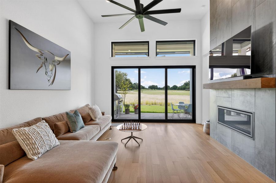 Floor-to-ceiling glass doors reveal an inspiring view of the golf course from this elegant living room. Floor-to-ceiling glass doors reveal an inspiring view of the golf course from this elegant living room.