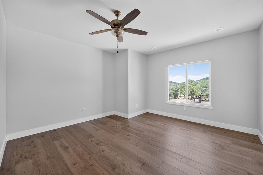 Rich wood-plank flooring pairs with a picture window framing serene, natural mountain vistas.