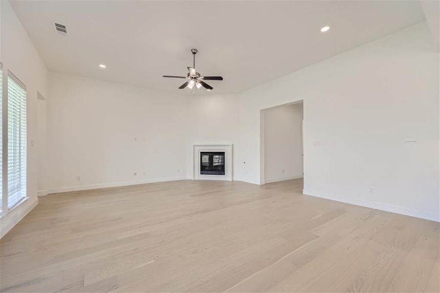 Unfurnished living room with ceiling fan and light hardwood / wood-style flooring