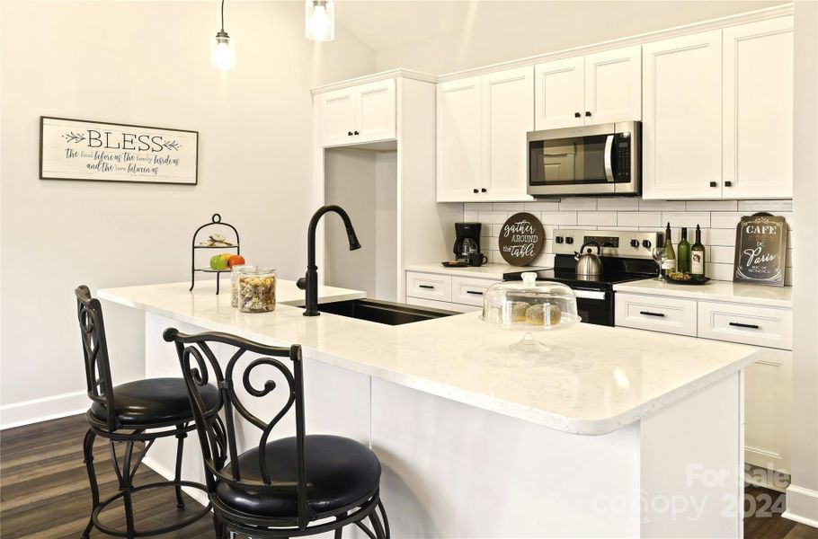 Close view of modern Kitchen with subway tile back splash & lots of shaker cabinets.