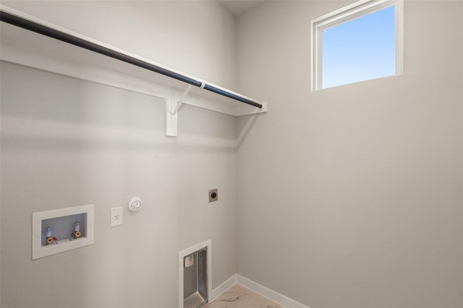 Washroom featuring hookup for a washing machine, gas dryer hookup, electric dryer hookup, and light marble finish floors Washroom featuring hookup for a washing machine, gas dryer hookup, electric dryer hookup, and light marble finish floors