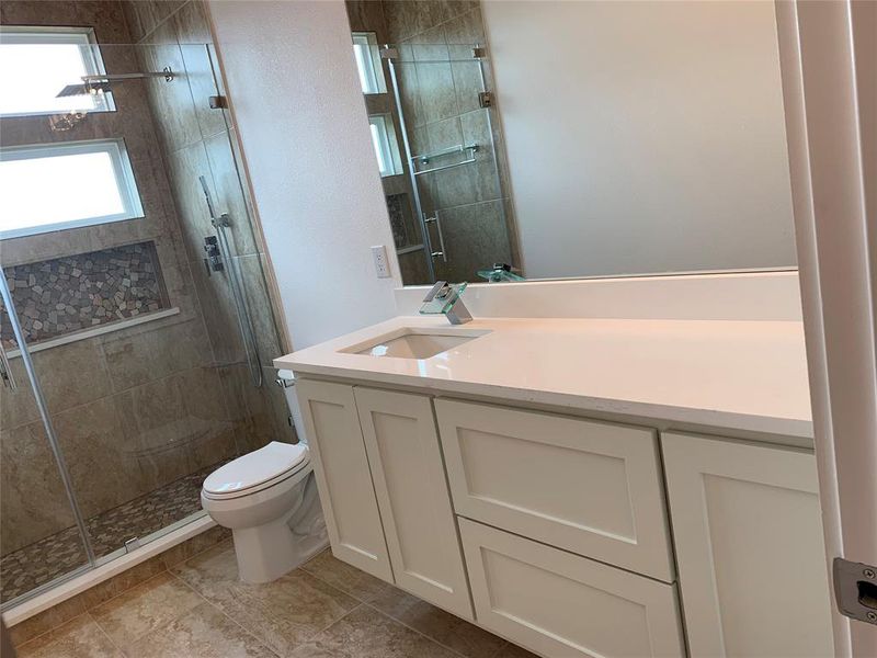 Bathroom featuring vanity, a stall shower, and light tile patterned flooring Bathroom featuring vanity, a stall shower, and light tile patterned flooring