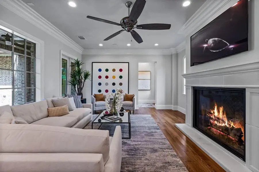 Living room featuring ceiling fan, hardwood / wood-style floors, and crown molding