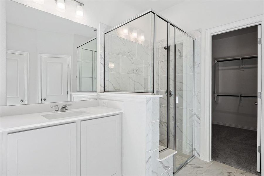 Bathroom with an enclosed shower, tile flooring, and vanity