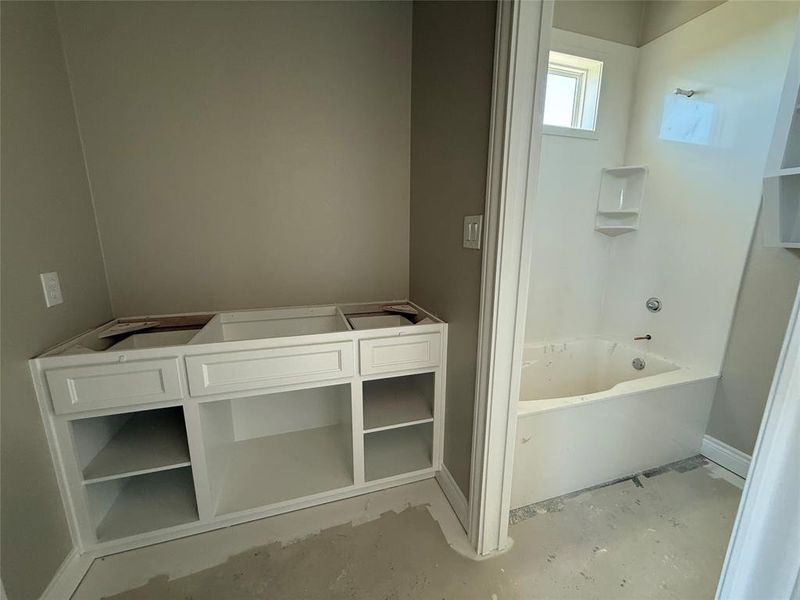 Bathroom with concrete floors and shower / tub combination