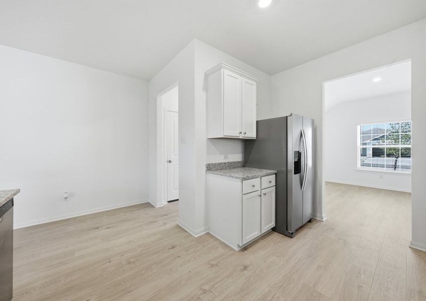 Kitchen featuring a stainless steel refrigerator, granite countertops, and a window with natural light. Kitchen featuring a stainless steel refrigerator, granite countertops, and a window with natural light.