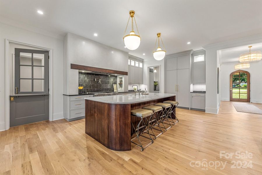 Amazing kitchen with warm wood island and gorgeous fixtures and selections