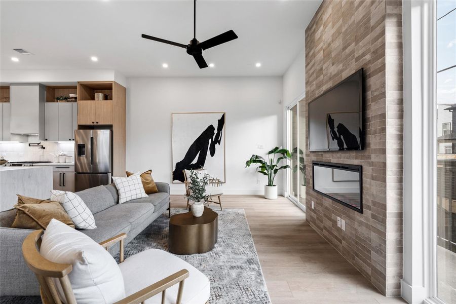 With its dramatic hearth and uninterrupted sightlines, this living area balances statement design with everyday comfort. Natural light and warm finishes create an atmosphere that feels calm, curated, and inviting.