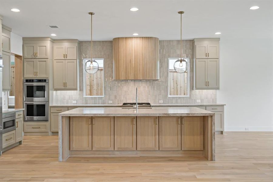 The massive island features incredible storage on both sides and the spacious kitchen offers double ovens, built in drawer microwave, built in refrigerator and gas cooktop.