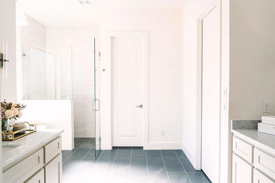 Bathroom featuring tile patterned flooring, vanity, and a shower with shower door