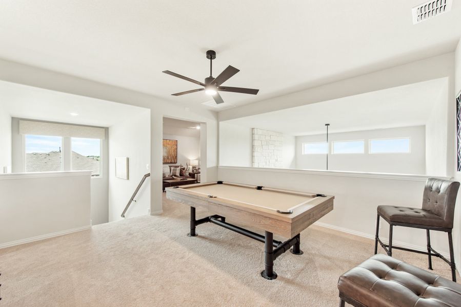 Game room with pool table, ceiling fan, carpet flooring, and leather seating near staircase landing