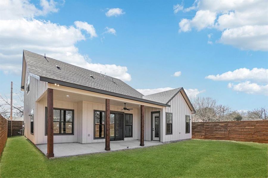 Back of property with a shingled roof, a fenced backyard, and a patio