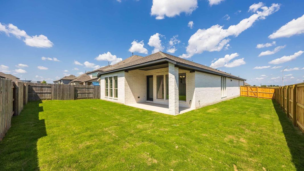 Rear view of property with brick siding, a patio, and a fenced backyard Rear view of property with brick siding, a patio, and a fenced backyard