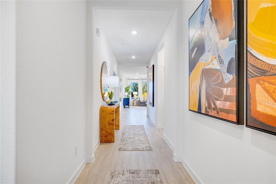 Corridor with light wood-style floors, baseboards, and recessed lighting