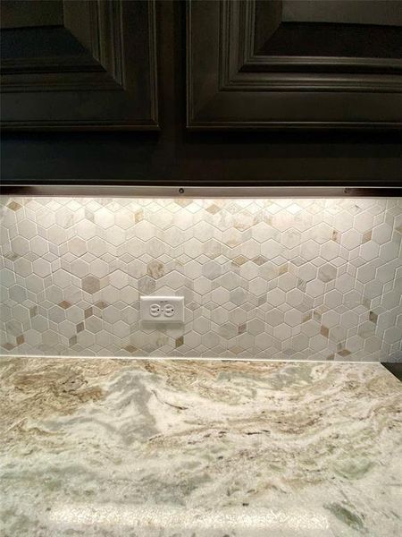 Slate Grey raised panel cabinets, Fantasy Brown granite, and decorative mosiaic tile backsplash.