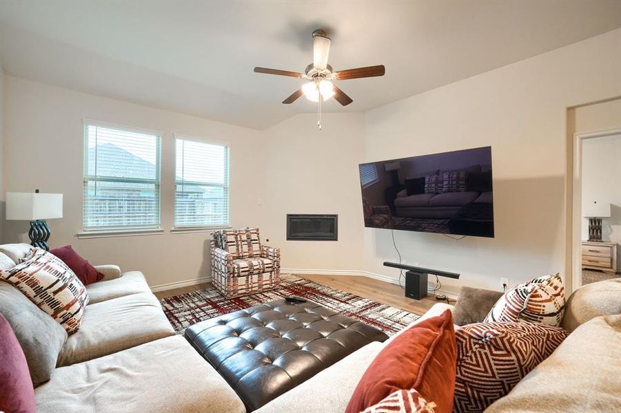 Living area with wood finished floors, ceiling fan, and vaulted ceiling Living area with wood finished floors, ceiling fan, and vaulted ceiling