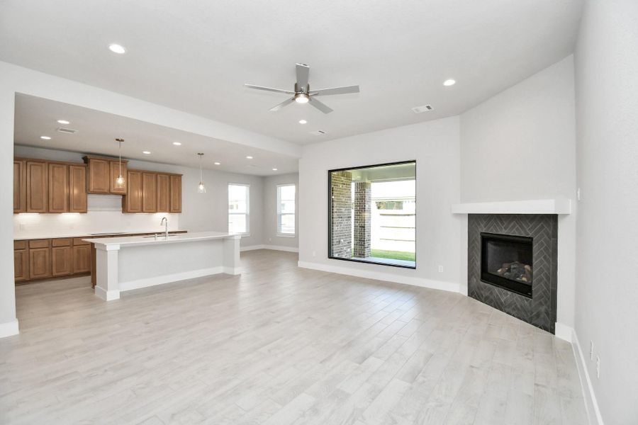 Welcome family and guests to your charming living room! With its high ceilings, recessed lighting, ceiling fan, custom paint, beautiful flooring, and a large window that lets in abundant natural light, this room is perfect for gatherings. Sample photo of completed home with similar floor plan. Actual colors and selections may vary. Welcome family and guests to your charming living room! With its high ceilings, recessed lighting, ceiling fan, custom paint, beautiful flooring, and a large window that lets in abundant natural light, this room is perfect for gatherings. Sample photo of completed home with similar floor plan. Actual colors and selections may vary.