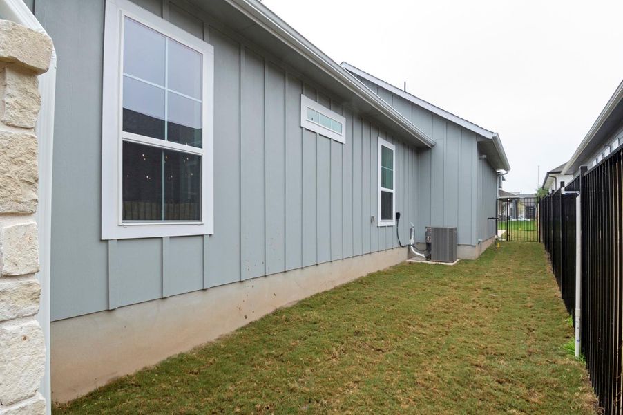 View of side of home with board and batten siding and a central AC unit