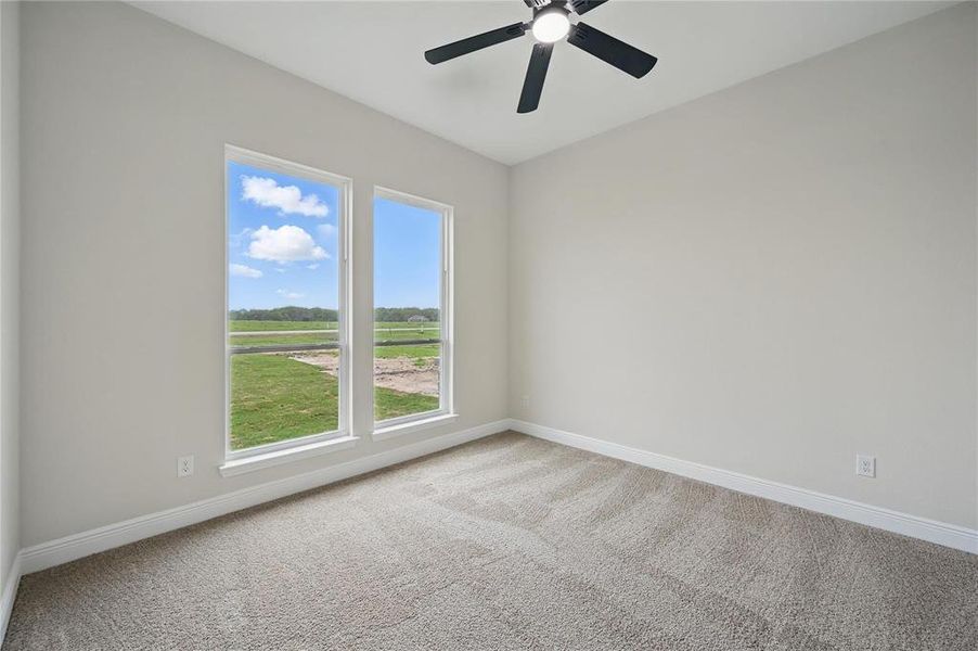 Carpeted spare room featuring baseboards and a ceiling fan Carpeted spare room featuring baseboards and a ceiling fan