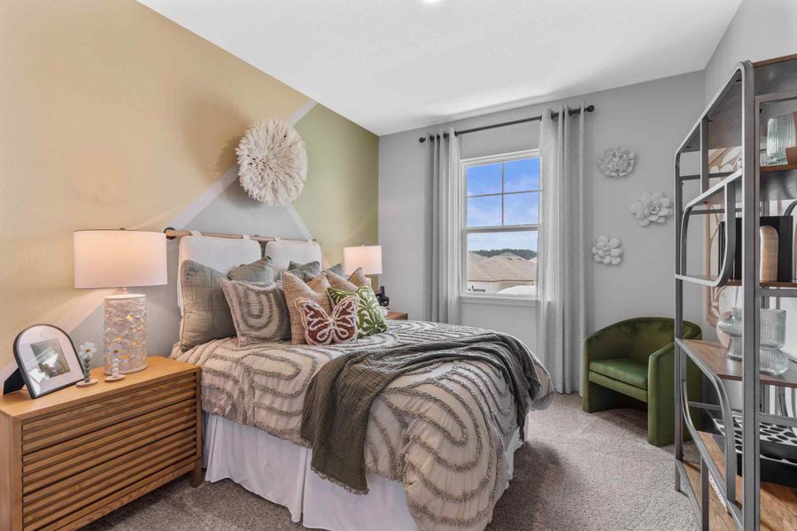 Silverbell II Model Home Guest Room with Bed and Open Shelving Unit at Camden Woods in Kingsland, GA