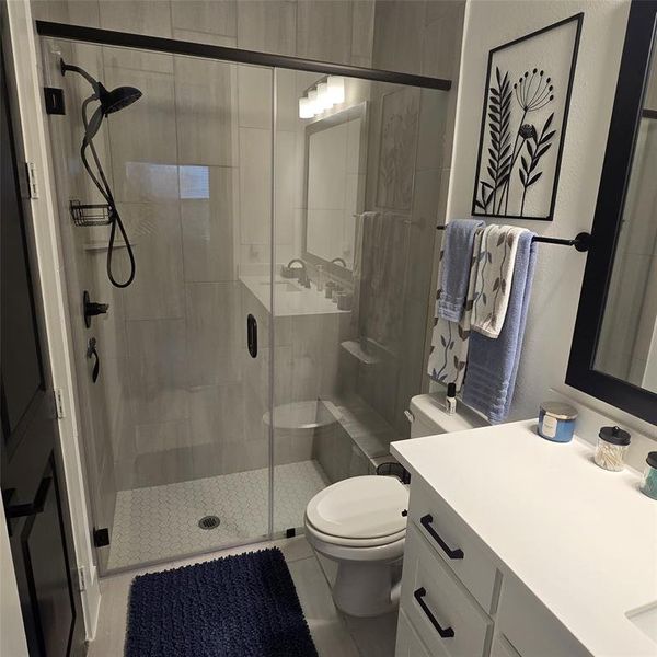 Bathroom featuring a shower stall, vanity, and tile patterned flooring Bathroom featuring a shower stall, vanity, and tile patterned flooring