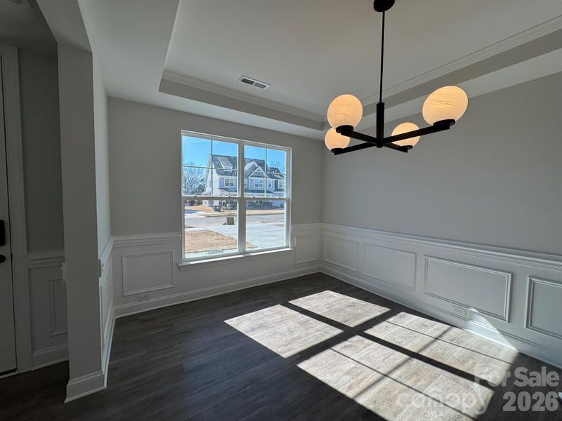 Dining room with tray ceiling and wainscoting