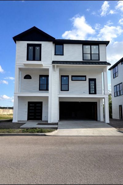 Architectural details such as double glass door entry and wrought iron balconies on the second and third floors.