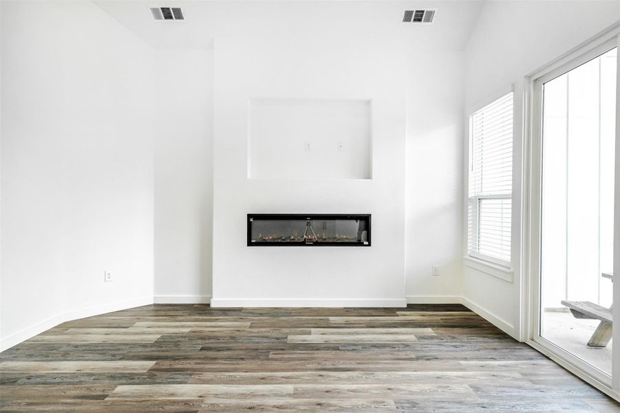A well-lit living area features an elegant fireplace and wood flooring, perfect for comfortable gatherings. A well-lit living area features an elegant fireplace and wood flooring, perfect for comfortable gatherings.
