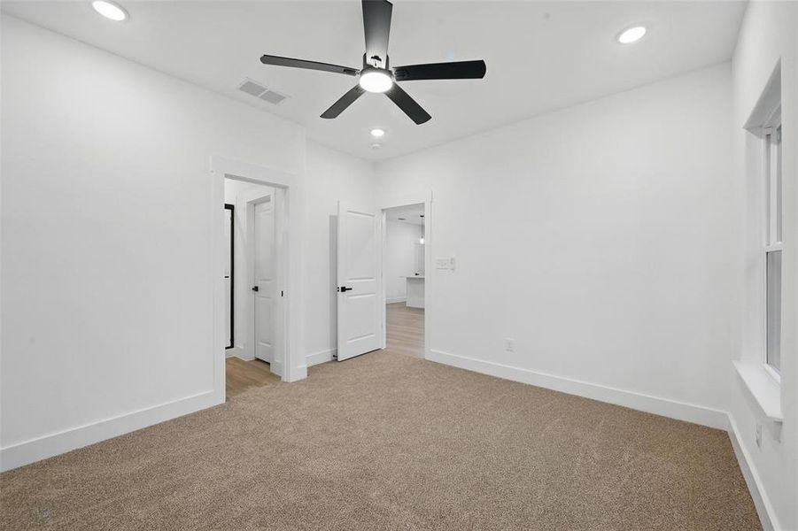 Unfurnished bedroom featuring light colored carpet, recessed lighting, baseboards, and ceiling fan