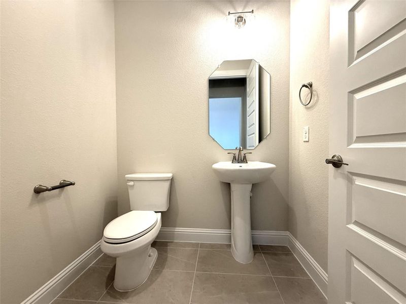 Bathroom featuring light tile patterned floors and a textured wall