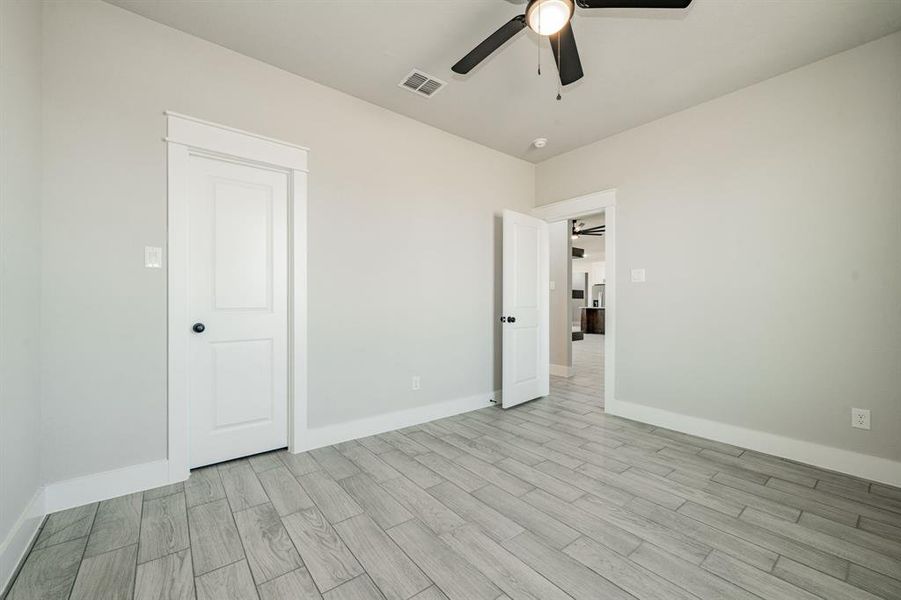 Bedroom featuring wood-tiled finish floors and a ceiling fan Bedroom featuring wood-tiled finish floors and a ceiling fan