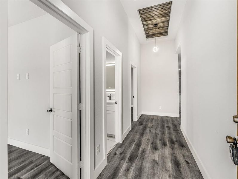 Corridor with a raised ceiling and dark wood-type flooring