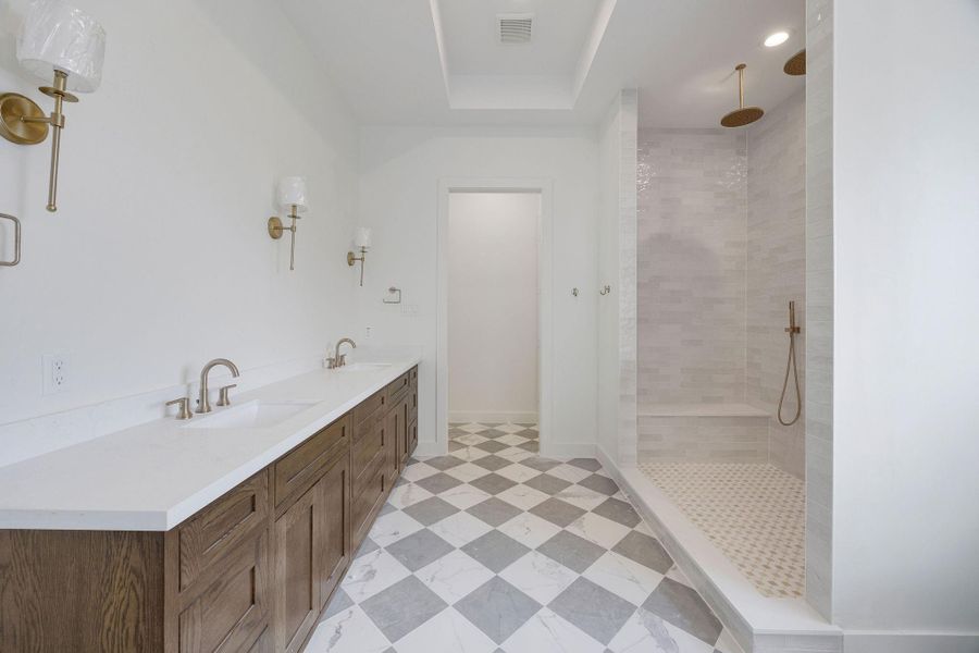 A polished mix of natural textures in this primary bathroom create a spa-like atmosphere. A polished mix of natural textures in this primary bathroom create a spa-like atmosphere.