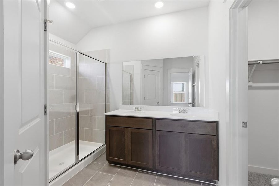 Bathroom featuring double vanity, a shower stall, light tile patterned flooring, recessed lighting, and a spacious closet