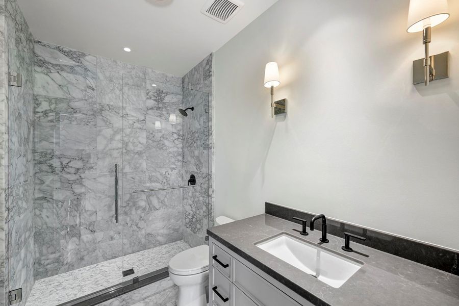 Ensuite bath with marble shower surround and floors.