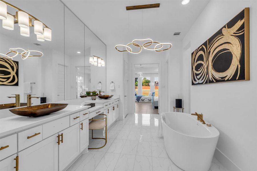 Primary Bathroom:A spa-inspired sanctuary, the primary bathroom exudes elegance with dual vanities, a sculptural soaking tub, and gold vessel sinks set against luminous tile. Designer lighting and expansive mirrors enhance the sense of space, creating a retreat of indulgence and modern sophistication.