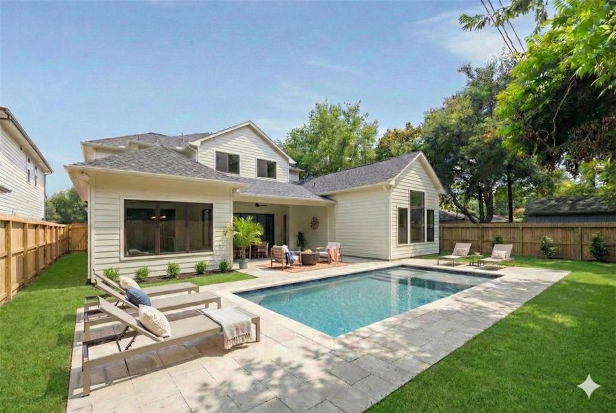 The ultimate backyard escape awaits. A stunning visualization of modern outdoor living. This design features a refreshing rectangular pool surrounded by an expansive travertine paver patio, dedicated lounging zones, and a comfortable covered seating area. (Please note: This is a digitally rendered image.)