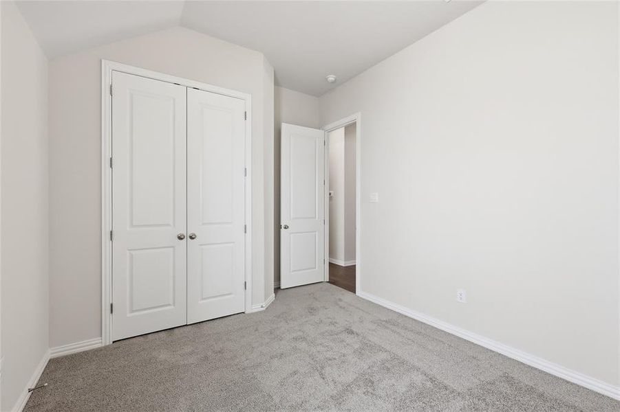 Unfurnished bedroom featuring light carpet and a closet Unfurnished bedroom featuring light carpet and a closet