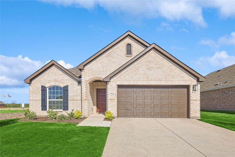 View of front of property featuring a garage and a front lawn