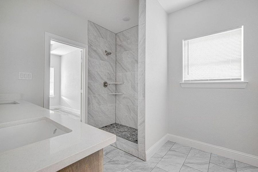 Bathroom featuring tile patterned flooring, shower with separate bathtub, and sink