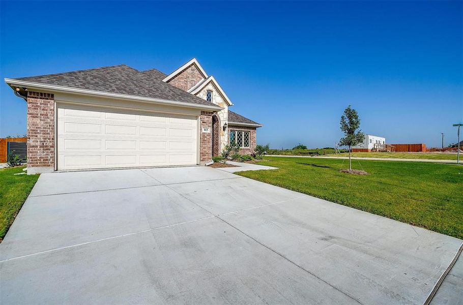 View of front of home with a garage and a front lawn