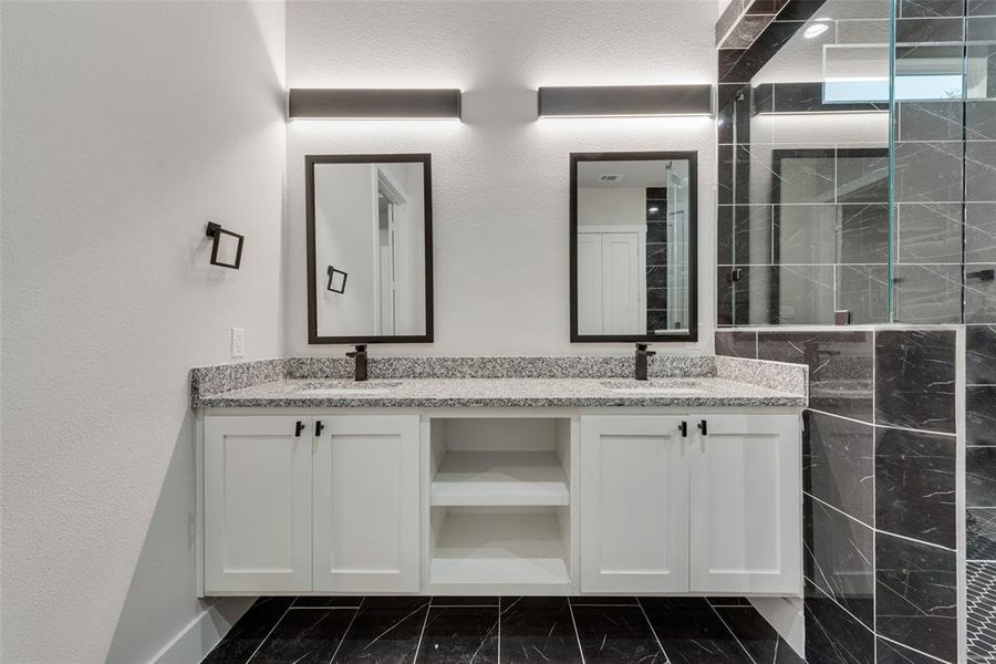 Bathroom with vanity and tiled shower