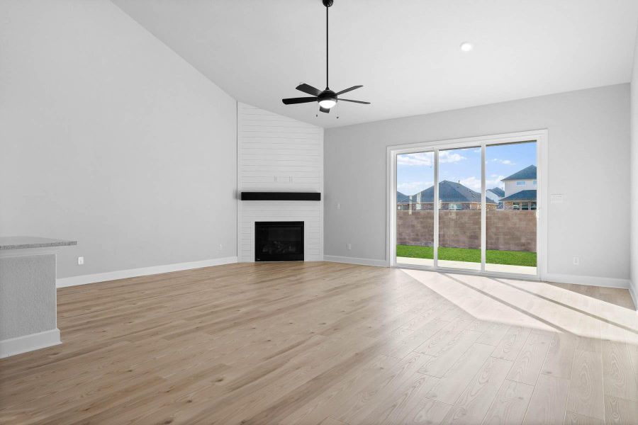 Expansive and inviting, the family room features a fireplace and large windows overlooking the covered back patio.