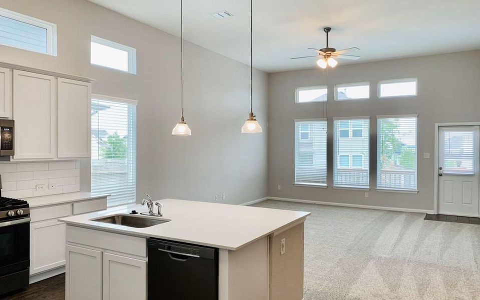 Bright and spacious family room filled with natural light from expansive windows, featuring soaring ceilings and an open view to the gourmet kitchen with a large center island, creating a warm and inviting space perfect for relaxing, entertaining, and everyday gatherings. **Photos are representative only and may vary as built.** Bright and spacious family room filled with natural light from expansive windows, featuring soaring ceilings and an open view to the gourmet kitchen with a large center island, creating a warm and inviting space perfect for relaxing, entertaining, and everyday gatherings. **Photos are representative only and may vary as built.**