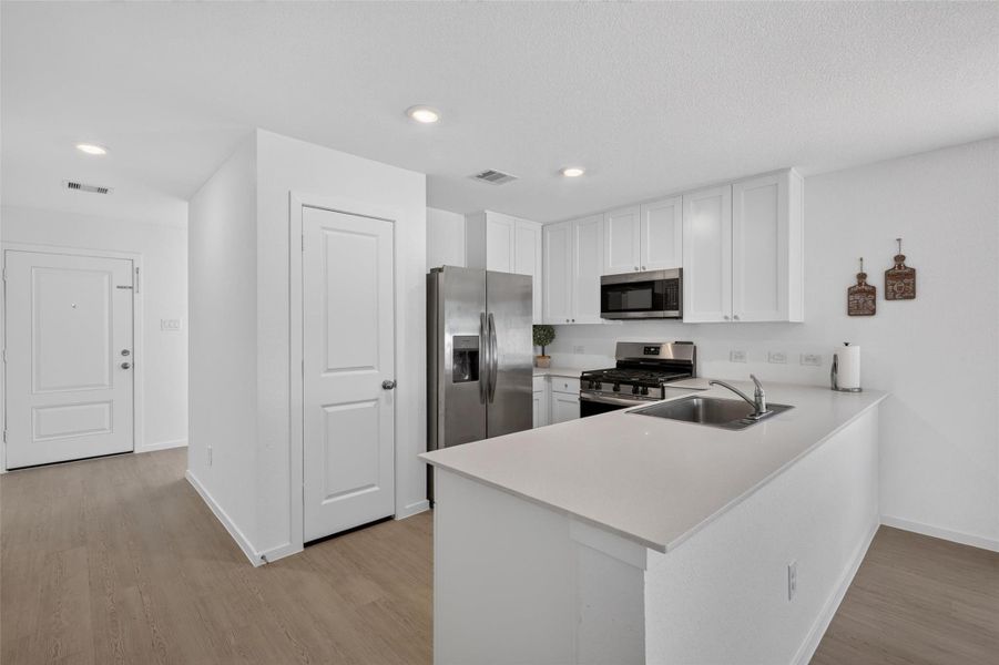 The kitchen offers generous cabinetry and counter space while remaining connected to the heart of the home.