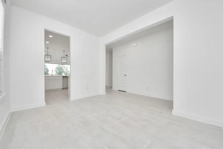 Create lasting memories with your family and friends at the dining table! This expansive dining room showcases sophisticated flooring, custom paint, and seamlessly connects to the family room and kitchen, providing an open and inviting atmosphere.