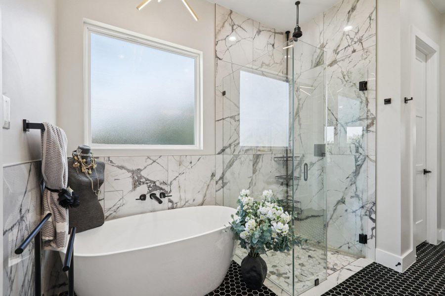 Bathroom with a marble finish shower and a soaking tub