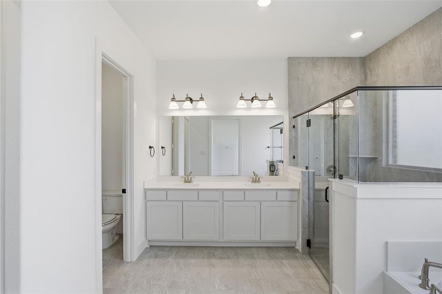 Bathroom featuring a shower stall, double vanity, and a bath