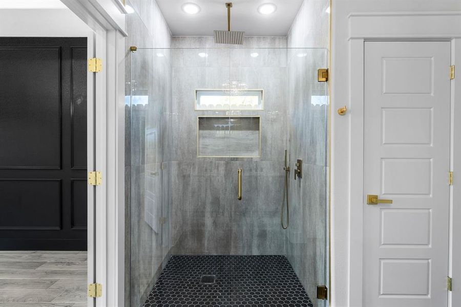 Bathroom with hardwood / wood-style flooring and a shower with shower door